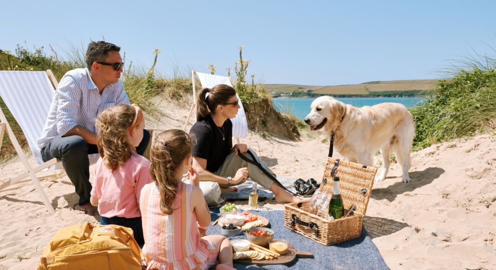 Family enjoying a beach trip with their dog, highlighting tips for memorable dog-friendly vacations