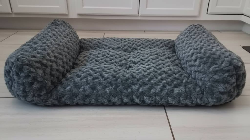 Plush memory foam dog bed with bolster sides for cozy pet rest